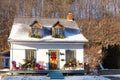 Beautiful small white french-style ancestral clapboard house with green trimmed yellow windows and door and grey shingled roof