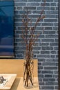 Beautiful small yellow flower in tall vases glass decorated living room with the gray brick wall background on wooden table Royalty Free Stock Photo