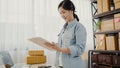 Beautiful smart Asian young entrepreneur business woman owner of SME checking product on stock and write on clipboard working at Royalty Free Stock Photo