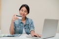 Beautiful smart business Asian woman using computer or laptop buying online shopping by credit card while wear smart casual Royalty Free Stock Photo