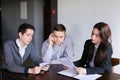 Young successful bankers two guys and girl check and agree docum Royalty Free Stock Photo