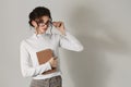 Beautiful smart young woman with a book in her hands and glasses. On a white background, a strict business woman Royalty Free Stock Photo