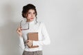 Beautiful smart young woman with a book in her hands and glasses. On a white background, a strict business woman Royalty Free Stock Photo