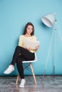 Beautiful smart young woman reading book sitting on the chair Royalty Free Stock Photo