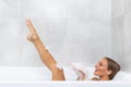 Beautiful smile woman washing leg in bath with foam, Young woman bathing in bathtub, relaxing in bath