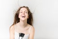 Beautiful smiley young girl blow drying her hair