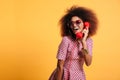 Beautiful smiling african woman in dress posing with retro phone Royalty Free Stock Photo