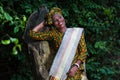 Beautiful smiling african woman standing against a tree Royalty Free Stock Photo