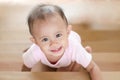 Beautiful smiling asian baby girl while crawling up a stair.