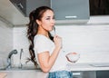 The beautiful smiling asian girl slim young woman having light breakfast in her kitchen