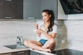 The beautiful smiling asian girl slim young woman having light breakfast in her kitchen Royalty Free Stock Photo