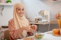 A beautiful Asian Muslim woman or housewife is making her healthy salad bowl in the kitchen Royalty Free Stock Photo