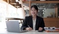 Beautiful smiling Asian woman working at the office, looking at the camera Royalty Free Stock Photo