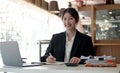 Beautiful smiling Asian woman working at the office, looking at the camera Royalty Free Stock Photo