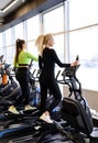 Athletic woman doing fitness cardio exercises in the gym on stepper machine. Two sporty women working out together Royalty Free Stock Photo