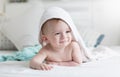 Portrait of beautiful smiling baby boy in white towel lying on bed Royalty Free Stock Photo