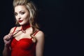 Beautiful smiling blond model with perfect make up and scrapped back hair wearing red corset strapped top and choker Royalty Free Stock Photo