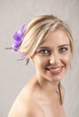 Beautiful smiling blonde girl with purple flower hair clip