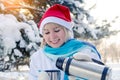 Beautiful smiling blonde girl in a red Christmas hat pours hot tea into a cup Royalty Free Stock Photo