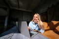 Smiling attractive woman lying on bed talking by smartphone