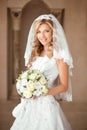 Beautiful smiling bride girl with bouquet of roses in wedding dr