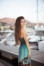Beautiful smiling brunette girl with long hair posing by yachts Royalty Free Stock Photo