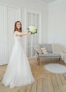 Beautiful smiling brunette woman bride in wedding dress with classical white roses bouquet, full length portrait Royalty Free Stock Photo