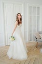 Beautiful smiling brunette woman bride in wedding dress with classical white roses bouquet, full length portrait Royalty Free Stock Photo