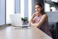 Beautiful smiling business woman is sitting in the office and looking at camera