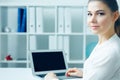 Beautiful smiling business woman sitting at office workplace half turn looking in camera portrait. Royalty Free Stock Photo