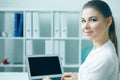 Beautiful smiling business woman sitting at office workplace half turn looking in camera portrait. Royalty Free Stock Photo