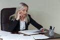 Beautiful smiling business woman working at her office desk with documents and talking on the phone. Royalty Free Stock Photo