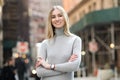 Beautiful smiling businesswoman with arms crossed standing outdoors on city street. Royalty Free Stock Photo