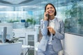 Beautiful smiling businesswoman talking on mobile phone at modern office. Royalty Free Stock Photo