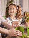 Beautiful smiling caucasian girl helps her mother to plant flowers. Home gardening. Happy childhood, positive emotions. Vertical Royalty Free Stock Photo