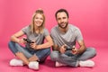 beautiful smiling couple playing video game with joysticks, isolated