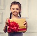 Beautiful smiling cute girl holding the gold box with gift with Royalty Free Stock Photo