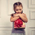 Beautiful smiling cute girl holding and hugging the gold box wit Royalty Free Stock Photo