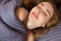 Beautiful smiling face of a young woman sleeping in bed close up Royalty Free Stock Photo