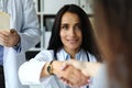 Beautiful smiling female GP shaking hands with visitor