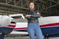 Beautiful Smiling Female Pilot in front of Airplane