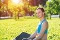 Beautiful smiling girl in activewear relax in park Royalty Free Stock Photo