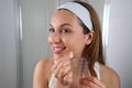 Beautiful smiling girl applying acne treatment patch on a pimple in bathroom Royalty Free Stock Photo