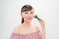 Beautiful smiling girl applying loose blush with cosmetic brush Royalty Free Stock Photo