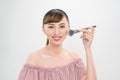 Beautiful smiling girl applying loose blush with cosmetic brush Royalty Free Stock Photo