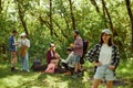 Beautiful, smiling girl in checkered shirt going hiking with friends. Group of young people walking, doing picnic in Royalty Free Stock Photo