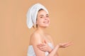 Beautiful smiling girl with clean fresh skin. Facial treatment. Cosmetology beauty and spa. Woman wrap towel on head put