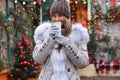 Beautiful smiling girl drinking tea, coffee or other hot drink in winter on the background of a christmas house Royalty Free Stock Photo