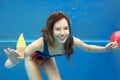 Beautiful smiling girl eating yellow ice cream underwater Royalty Free Stock Photo