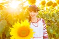 Beautiful smiling girl in embrodery on a sunflower field Royalty Free Stock Photo